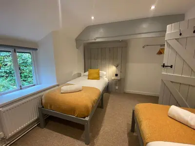 a small room with two beds and a window at Farmhouse with Log Fire & On-Site Dog Field in Bryn-crug
