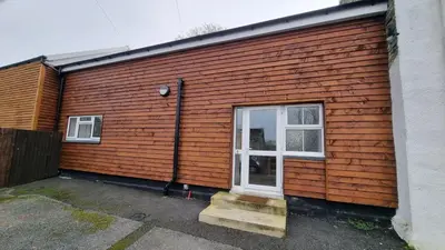 a wooden house with a door and stairs on it at Cottage #1 in Aberystwyth