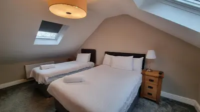 a bedroom with two beds and a window at Cottage #1 in Aberystwyth