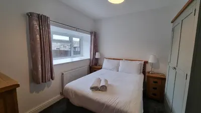 a bedroom with a bed with two slippers on it at Cottage #1 in Aberystwyth