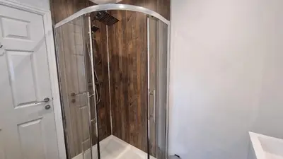 a shower with a glass door in a bathroom at Cottage #1 in Aberystwyth