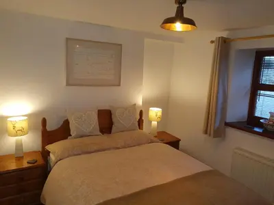 a bedroom with two beds and two lamps and a window at Ty Barcud in Lampeter