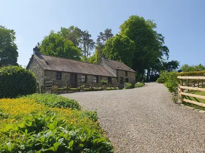an old stone house with a fence in front of it at Ty Twt in Lampeter