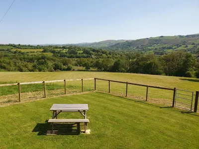 a picnic table sitting in the middle of a field at Ty Twt in Lampeter
