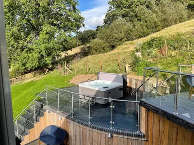 a hot tub on the deck of a house at Pennant Uchaf in Llanbrynmair