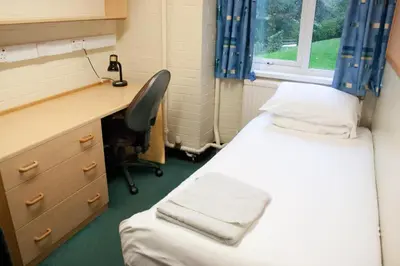 a room with two beds and a desk and a chair at Aberystwyth University Bunkhouse in Aberystwyth