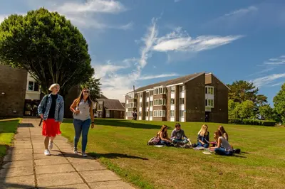 a group of people walking down a sidewalk on a campus at Aberystwyth University Bunkhouse in Aberystwyth