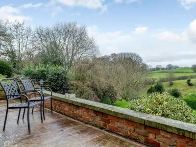 two chairs sitting on top of a brick wall at Old Upper Gwestydd in Highgate