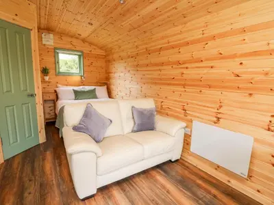 a living room with a white couch in a wooden room at Hwyl in Llandrindod Wells