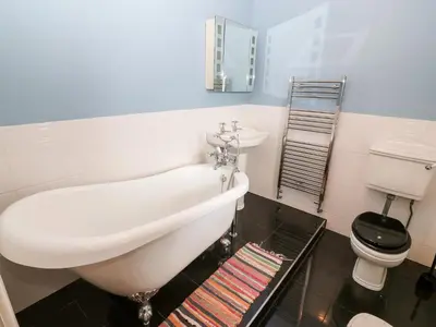 a bathroom with a sink and a tub and a toilet at Gerlan in Harlech