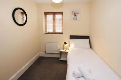 a bedroom with a bed and a table with a mirror at St Julians Place in Shrewsbury