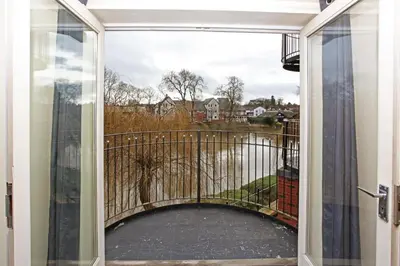 a glass door leading to a balcony with a walkway at St Julians Place in Shrewsbury