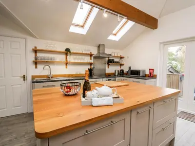a kitchen with a wooden counter top and a sink at Bridgend Cottages in Llandrindod Wells