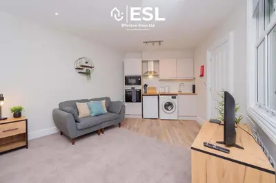 a living room with a couch and a tv at Studio 2, Second Floor Town Centre Apartment in Shrewsbury