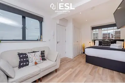 a bedroom with a bed and a couch at Studio 3, Top Floor Town Centre Apartment in Shrewsbury