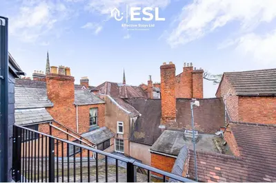 a view of the roofs of a city with brick buildings at Studio 3, Top Floor Town Centre Apartment in Shrewsbury