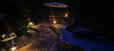 a table with an umbrella on a patio at night at Modern and spacious 2 bedroom apartment with free parking in Glyn-Ceiriog