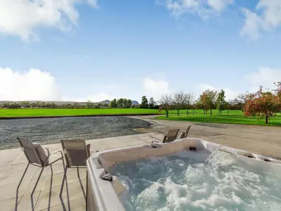 a jacuzzi tub with chairs and a golf course at Buckley Farm, Barn 2 - Uk36586 in Oswestry