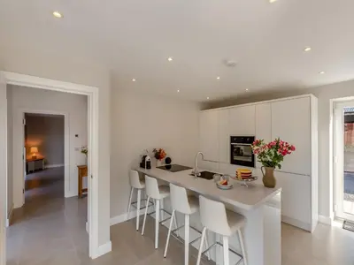 a kitchen with white cabinets and a island with stools at Buckley Farm, Barn 2 - Uk36586 in Oswestry
