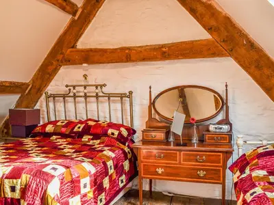 a bedroom with a bed and a dresser with a mirror at Ty Fferm Hen - Uk36420 in Talybont