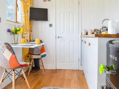 a small kitchen with a table and chairs at Ty Olwyn Bach - Uk36418 in Talybont
