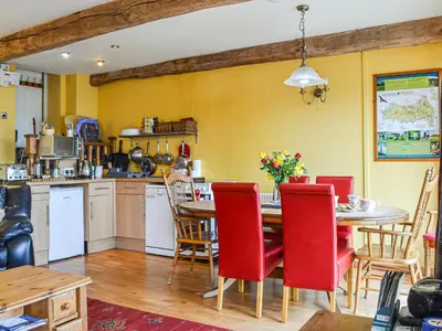 a kitchen and dining room with a table and chairs at Peacock Cottage - Uk36422 in Talybont