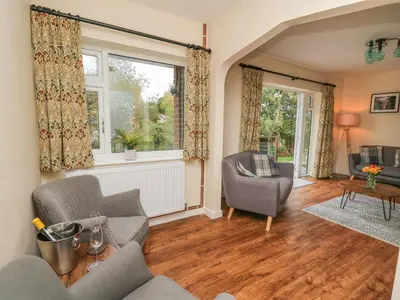 a living room with a couch and chairs and a window at Ger Yr Afon Cottage in Rhayader