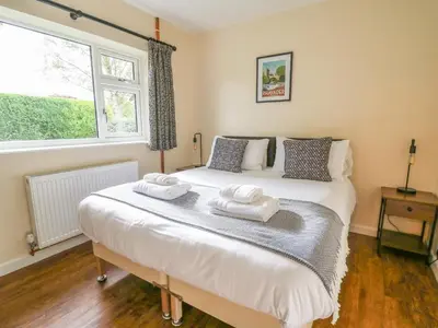 a bedroom with a bed with two towels on it at Ger Yr Afon Cottage in Rhayader
