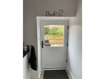 a door leading into a hallway with a window at The Good Life Wales with Hot tubs in Llywel