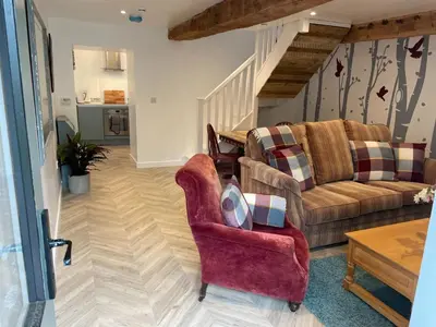 a living room with a couch and a chair at The Good Life Wales with Hot tubs in Llywel