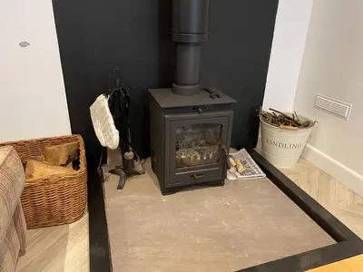 a fireplace in a living room with a stove at The Good Life Wales with Hot tubs in Llywel