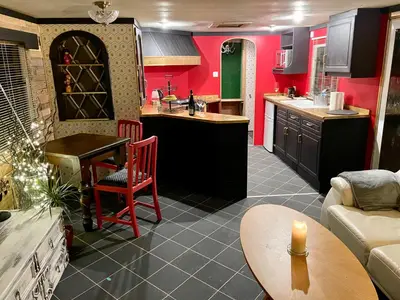 a kitchen and living room with red walls and a table at The Good Life Wales with Hot tubs in Llywel