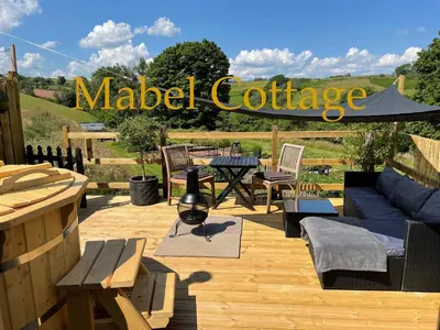 a patio with a couch and a table and chairs at The Good Life Wales with Hot tubs in Llywel