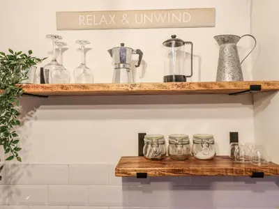 a wooden shelf with glass jars on it at Pengeulan in Machynlleth
