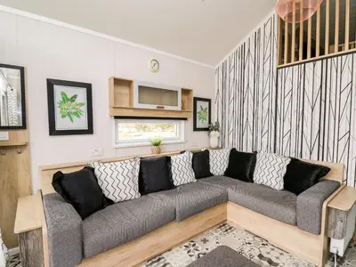 a living room with a gray couch in a room at Hillside Lodge in Rhayader