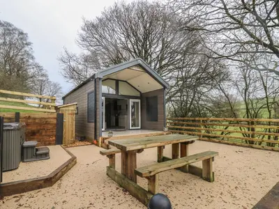a tiny house with a picnic table and a bench at Woodland Escape in Rhayader