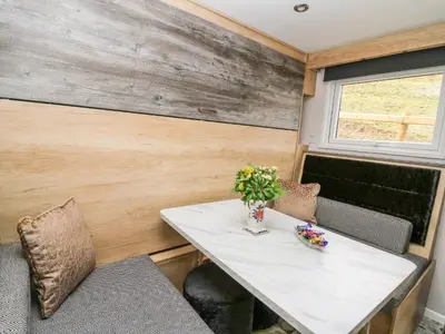 a dining room with a table and chairs and a window at Hares Rest in Rhayader