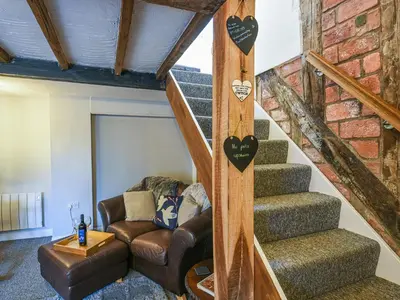 a living room with a staircase and a couch at Bodeinion in Llanfair Caereinion