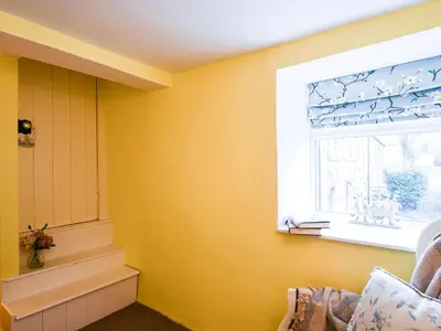 a yellow room with a window and a window sill at Glasfor in Llwyngwril