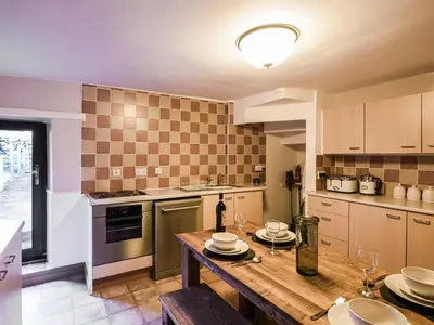 a kitchen with a wooden table with plates on it at Glasfor in Llwyngwril