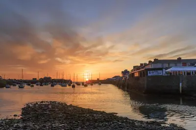 a sunset over a body of water with boats at 1 Bed in Aberaeron oc-bow300 in Henfynyw Upper