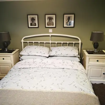 a bedroom with a white bed with two night stands at Rooms by the River at Glan Aber in Cynwyd