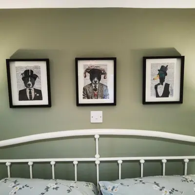 a bedroom with three framed pictures on the wall at Rooms by the River at Glan Aber in Cynwyd