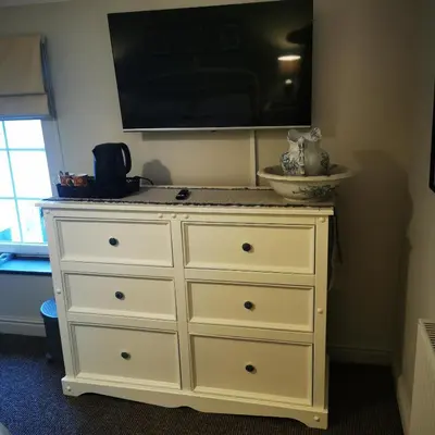 a white dresser with a tv on top of it at Rooms by the River at Glan Aber in Cynwyd