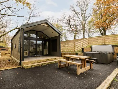 a small cabin with a picnic table and a fence at Oak Tree View in Rhayader