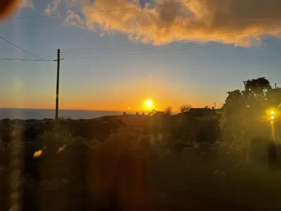a sunset with the sun setting in the sky at Bwthyn Nain Cottage near Harlech with ocean views in Llanfair