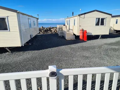 a row of mobile homes parked next to the ocean at Barmouth Lyons Sunnysands 346 in Talybont