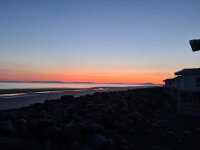a view of the beach at sunset at Barmouth Lyons Sunnysands 346 in Talybont