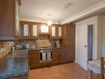 a kitchen with wooden cabinets and a sink at The Coach House in Oswestry