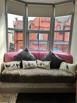 a couch sitting in front of a window with pillows at Cadwgan House in Rhayader